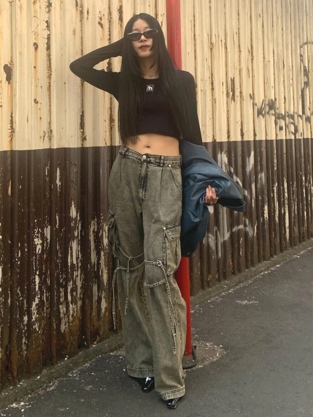 ブラック系のサンダル、ブラック系のTシャツ/カットソー、ブラック系のデニムパンツを着用したレディースの春コーディネートの2枚目の写真