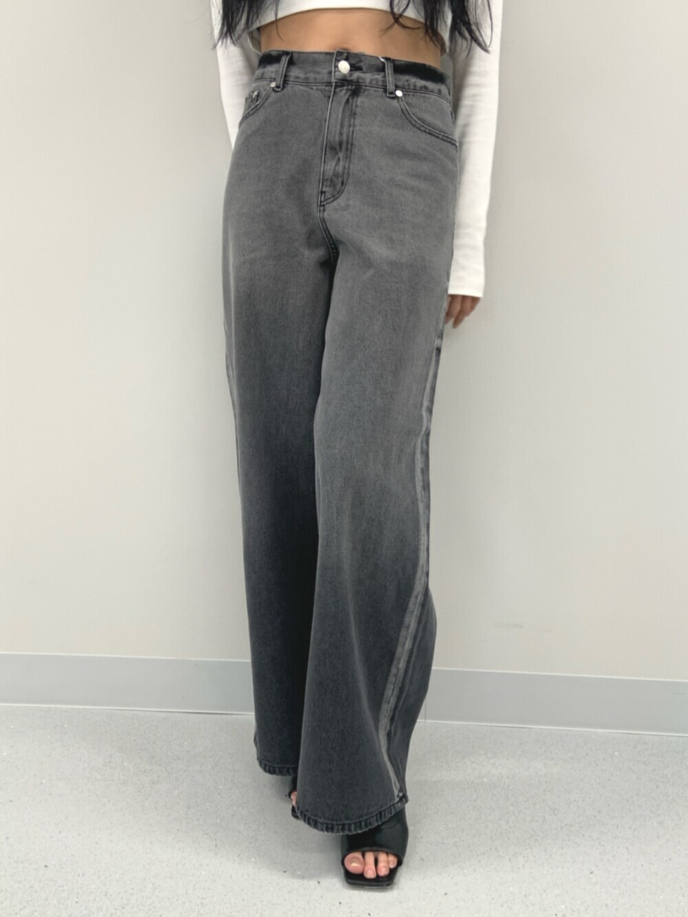 ホワイト系のTシャツ/カットソー、ブラック系のブーツ、ブラック系のデニムパンツを着用したレディースの春コーディネートの5枚目の写真