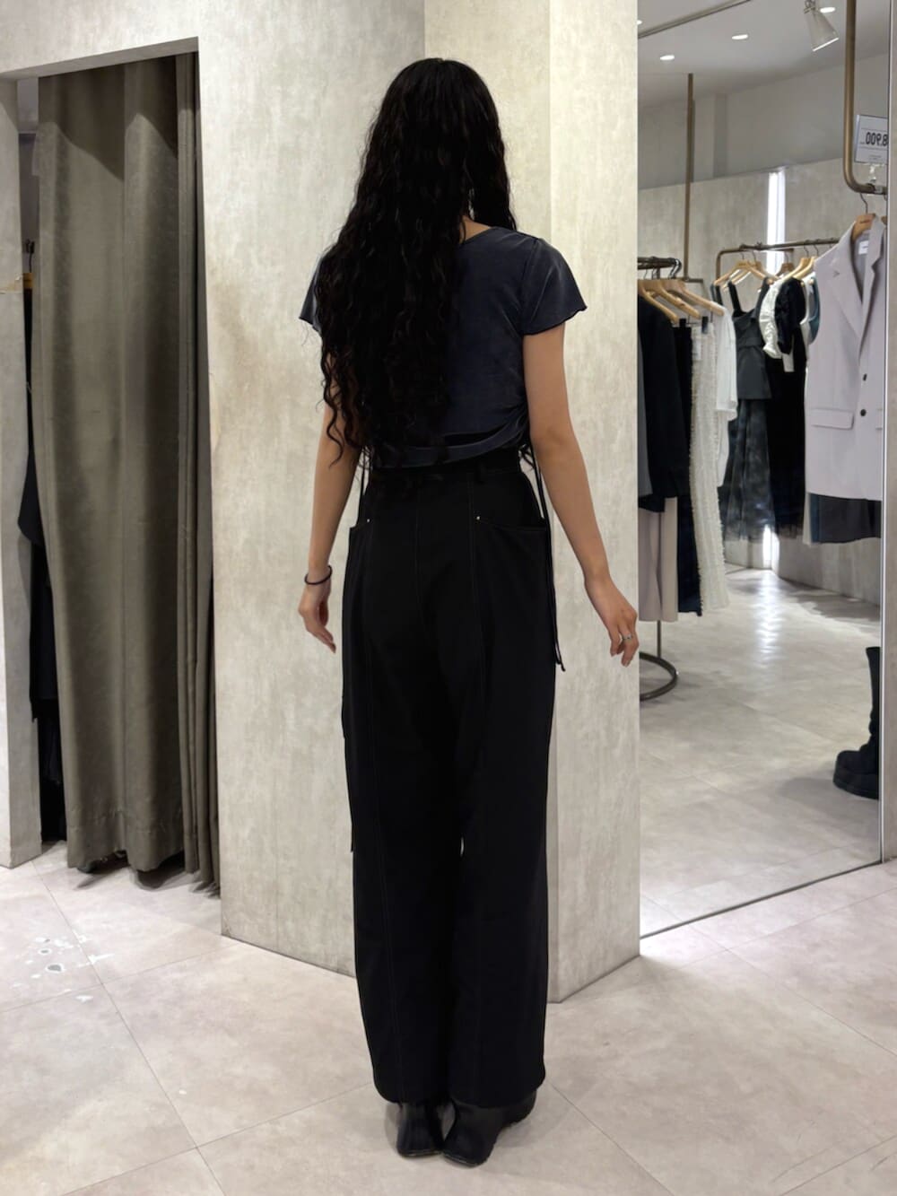 ブラック系のスラックス、ブラック系のサンダル、ブルー系のTシャツ/カットソーを着用したレディースの春コーディネートの3枚目の写真