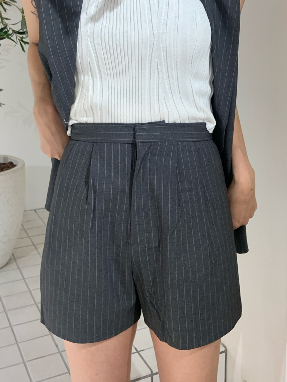 グレー系のベスト、ホワイト系のタンクトップ、グレー系のその他パンツを着用したレディースの夏コーディネートの6枚目の写真