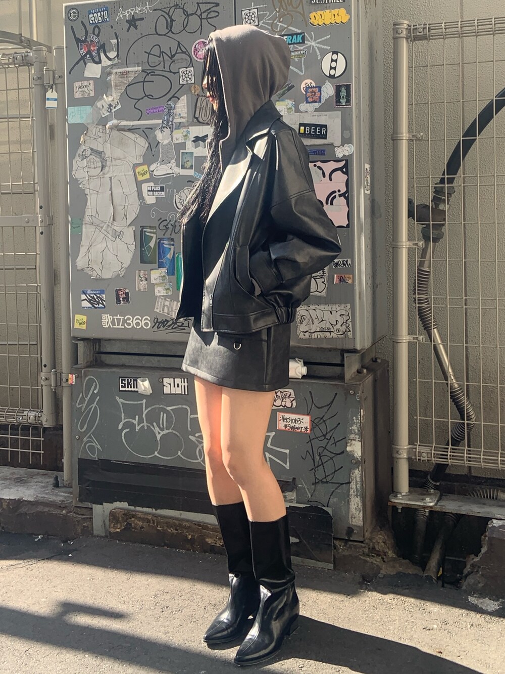 ブラック系のブルゾン、ブラック系のスカート、グレー系のパーカーを着用したレディースの冬コーディネートの3枚目の写真