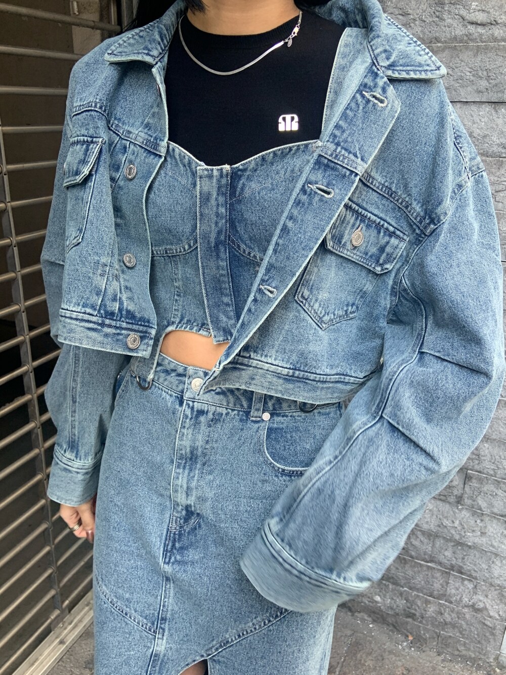 ブラック系のニット/セーター、ブルー系のデニムジャケット、ブルー系のその他トップスを着用したレディースの冬コーディネートの6枚目の写真