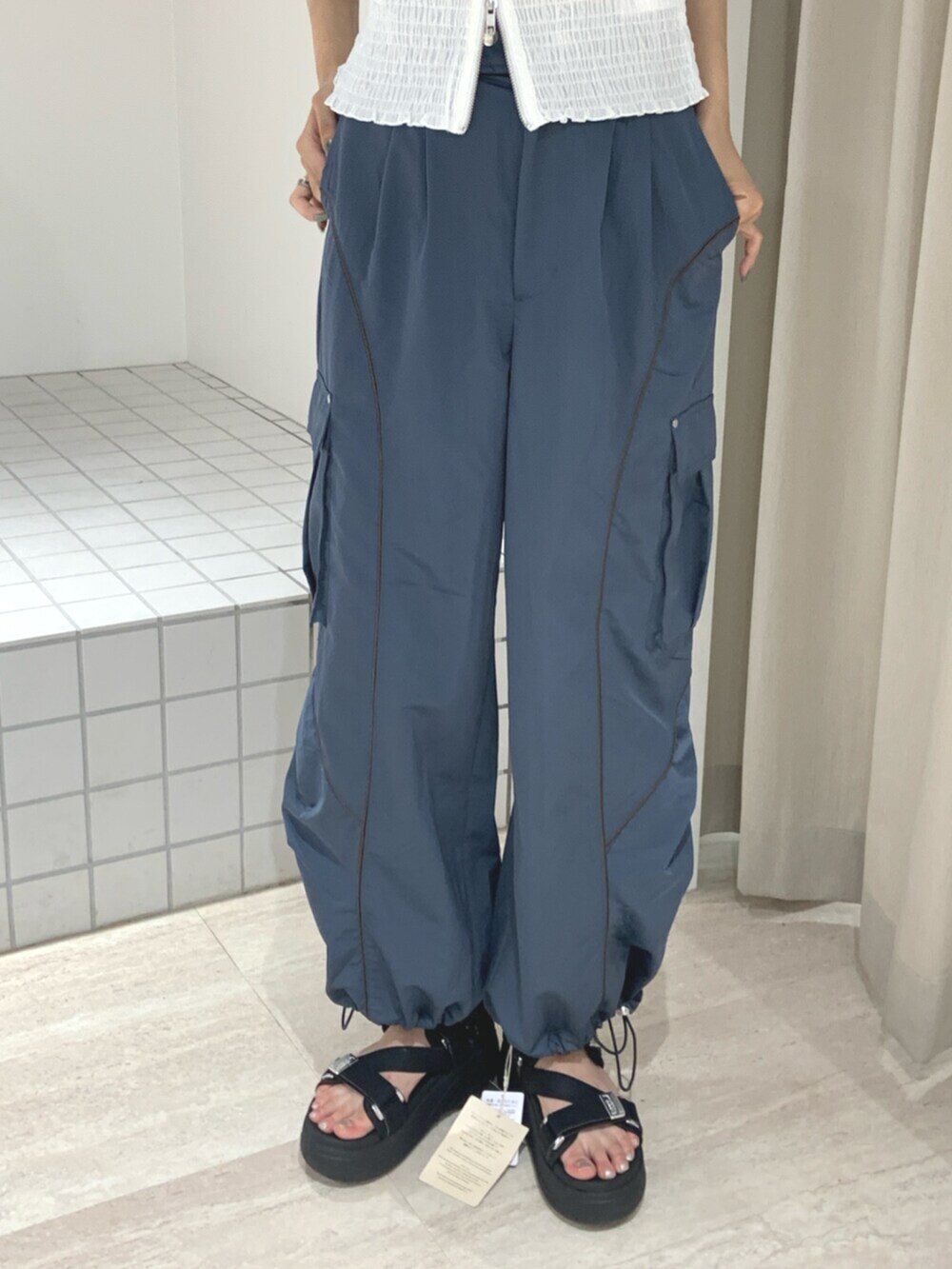 ブラック系のサンダル、ホワイト系のシャツ/ブラウス、ブルー系のカーゴパンツを着用したレディースの夏コーディネートの6枚目の写真