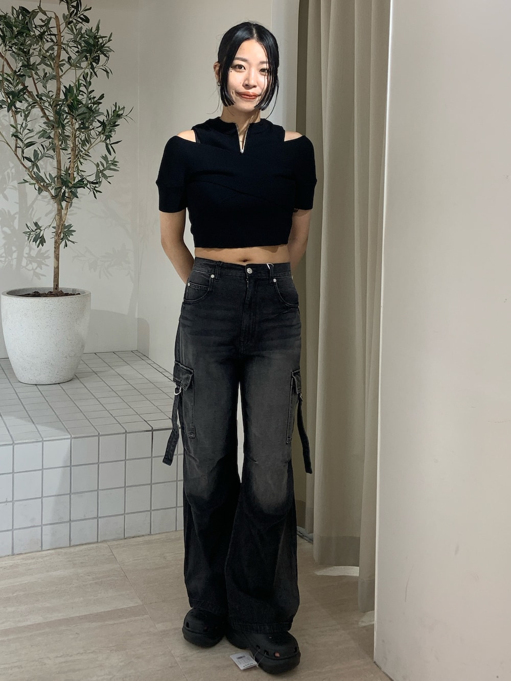 ブラック系のニット/セーター、ブラック系のデニムパンツ、ブラック系のサンダルを着用したレディースの夏コーディネートの2枚目の写真