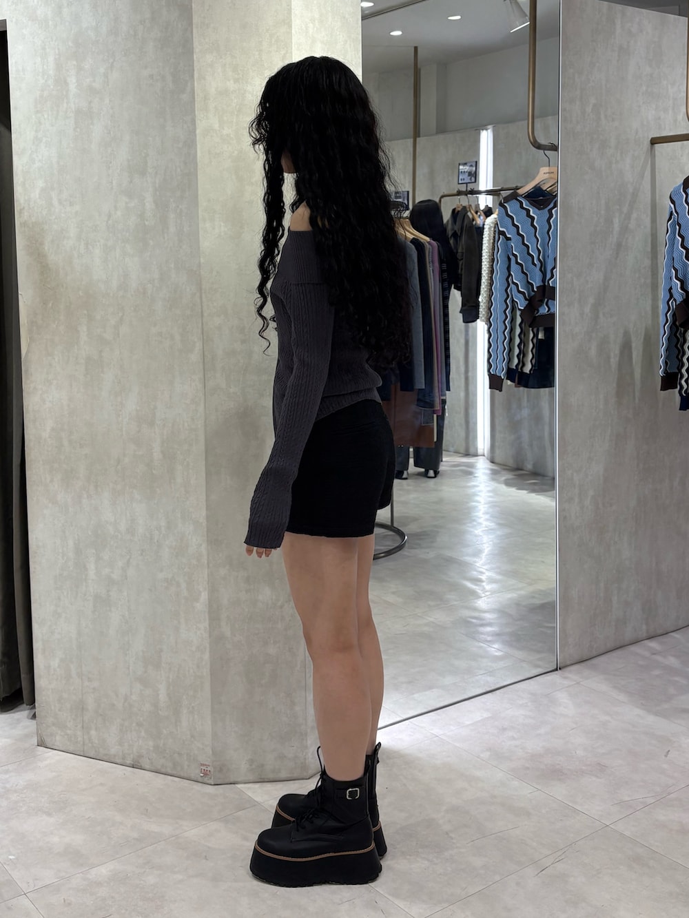 グレー系のニット/セーター、ブラック系のその他パンツ、ブラック系のブーツを着用したレディースの春コーディネートの2枚目の写真