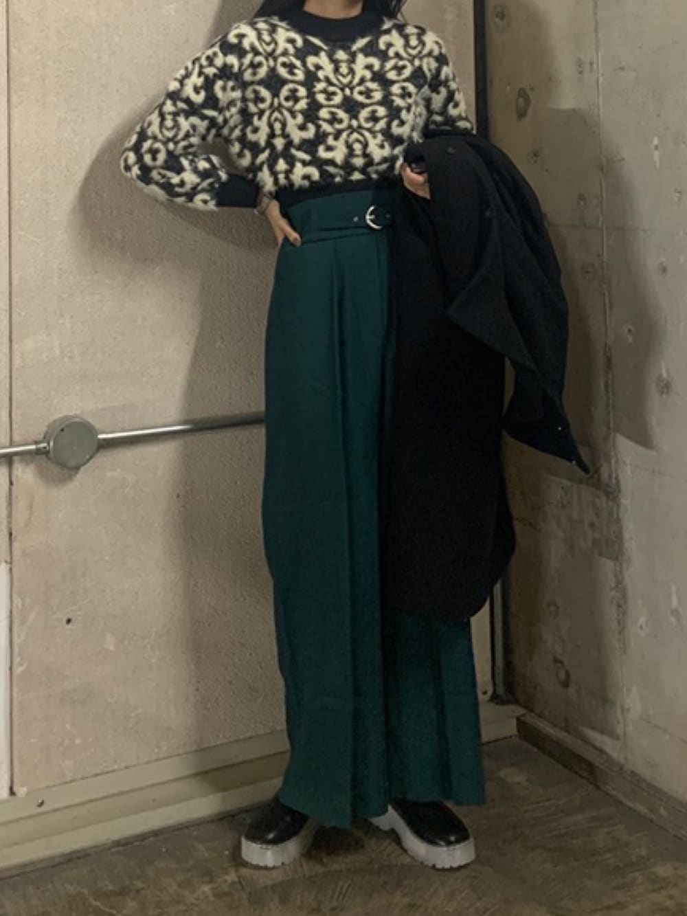 グリーン系のその他パンツ、ブラック系のニット/セーター、ブラック系のステンカラーコートを着用したレディースの秋コーディネートの4枚目の写真