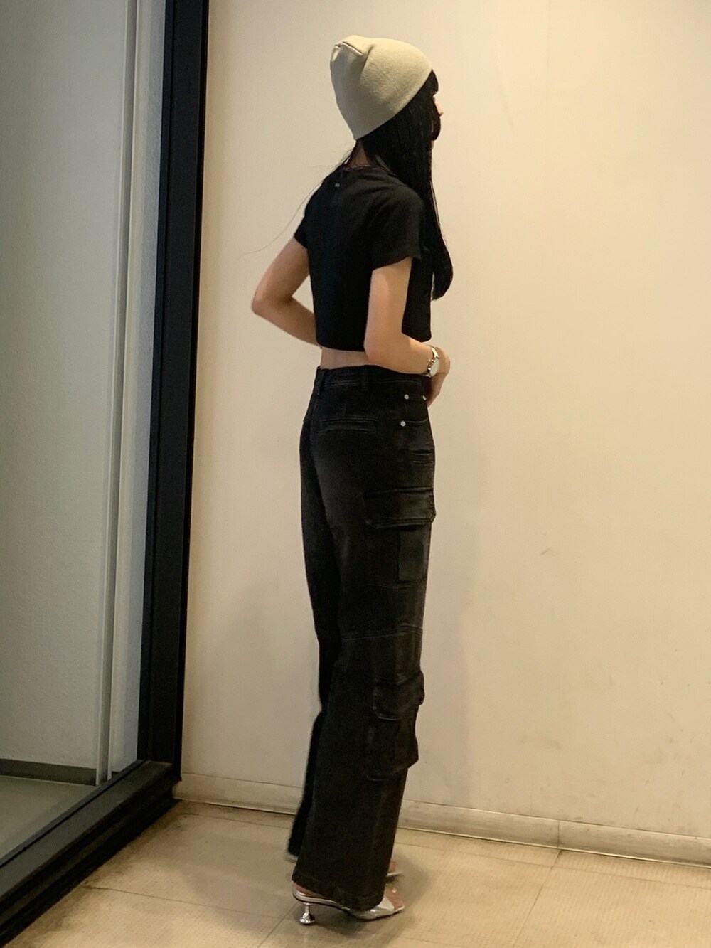 ブラック系のTシャツ/カットソー、ブラック系のデニムパンツ、シルバー系のサンダルを着用したレディースの春コーディネートの3枚目の写真