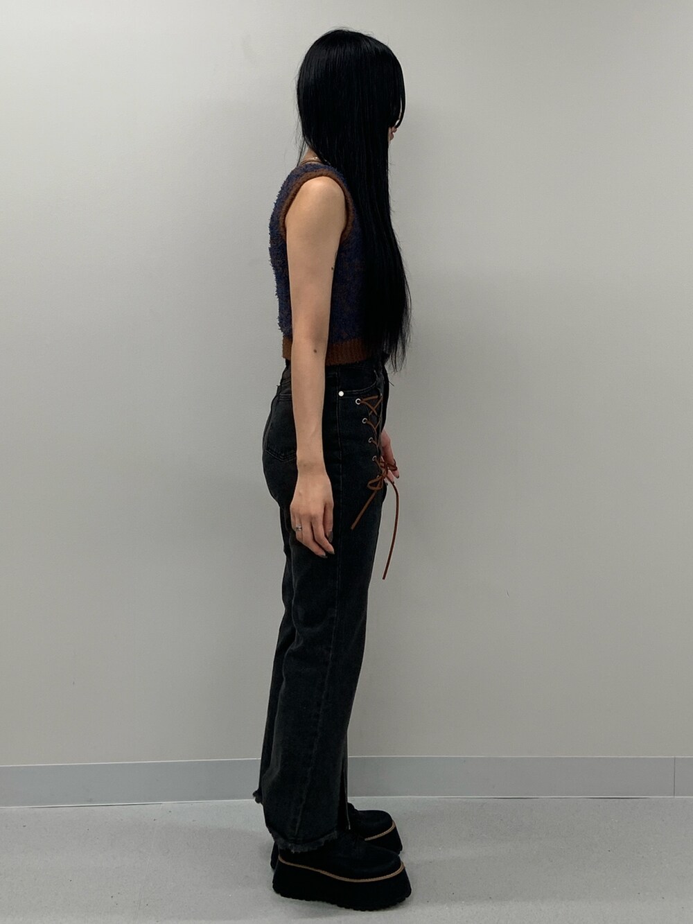 ブラック系のデニムパンツ、ブラック系のブーツ、ブラウン系のニット/セーターを着用したレディースの夏コーディネートの3枚目の写真