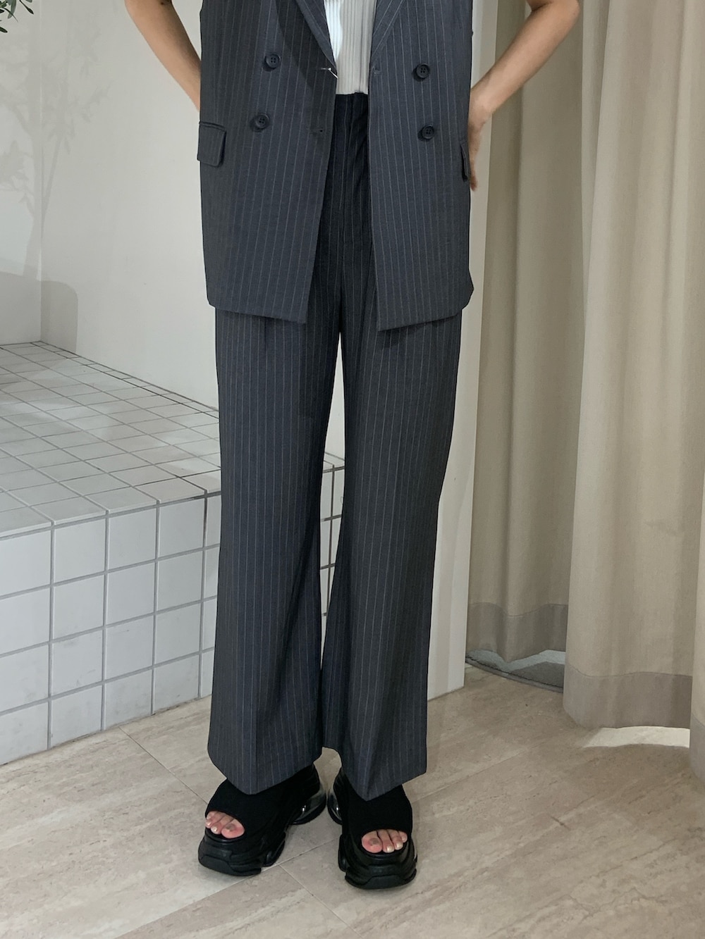 ホワイト系のタンクトップ、グレー系のその他パンツ、ブラック系のサンダルを着用したレディースの夏コーディネートの6枚目の写真