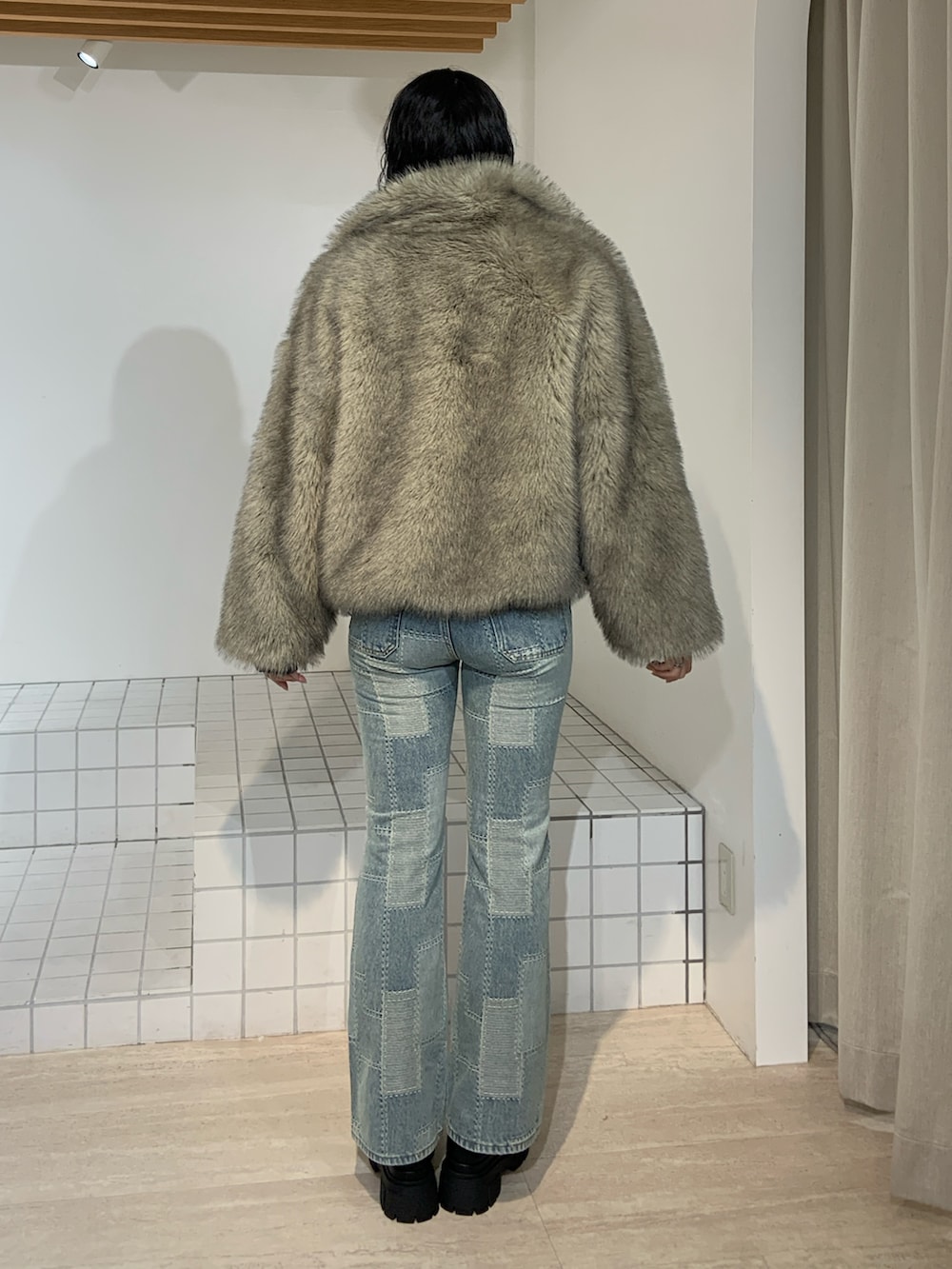 グレー系のブルゾン、ブルー系のデニムパンツを着用したレディースの秋コーディネートの3枚目の写真