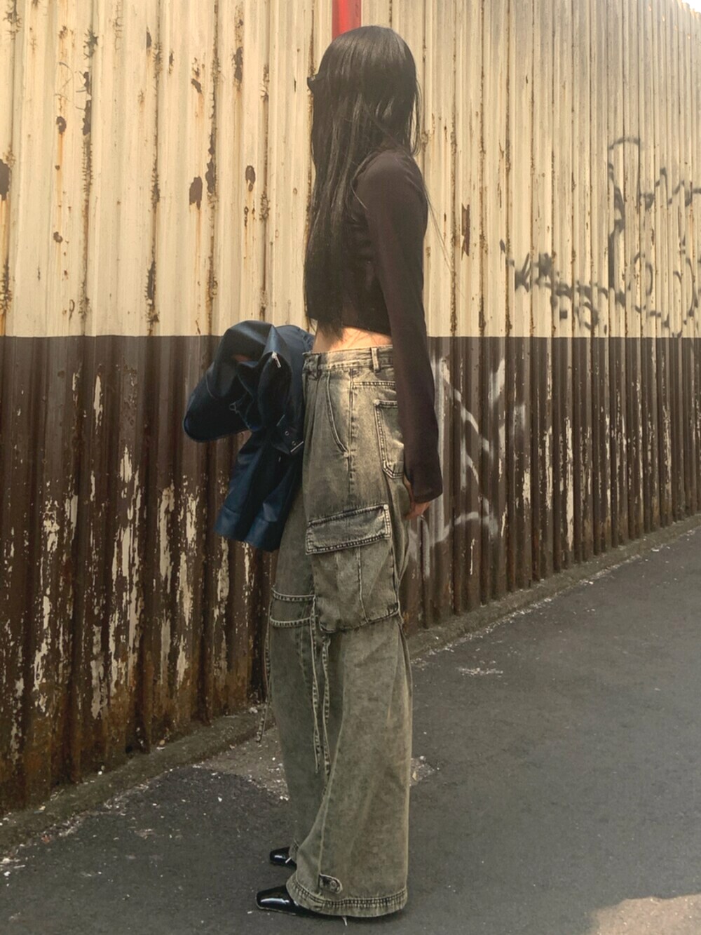 ブラック系のサンダル、ブラック系のTシャツ/カットソー、ブラック系のデニムパンツを着用したレディースの春コーディネートの3枚目の写真