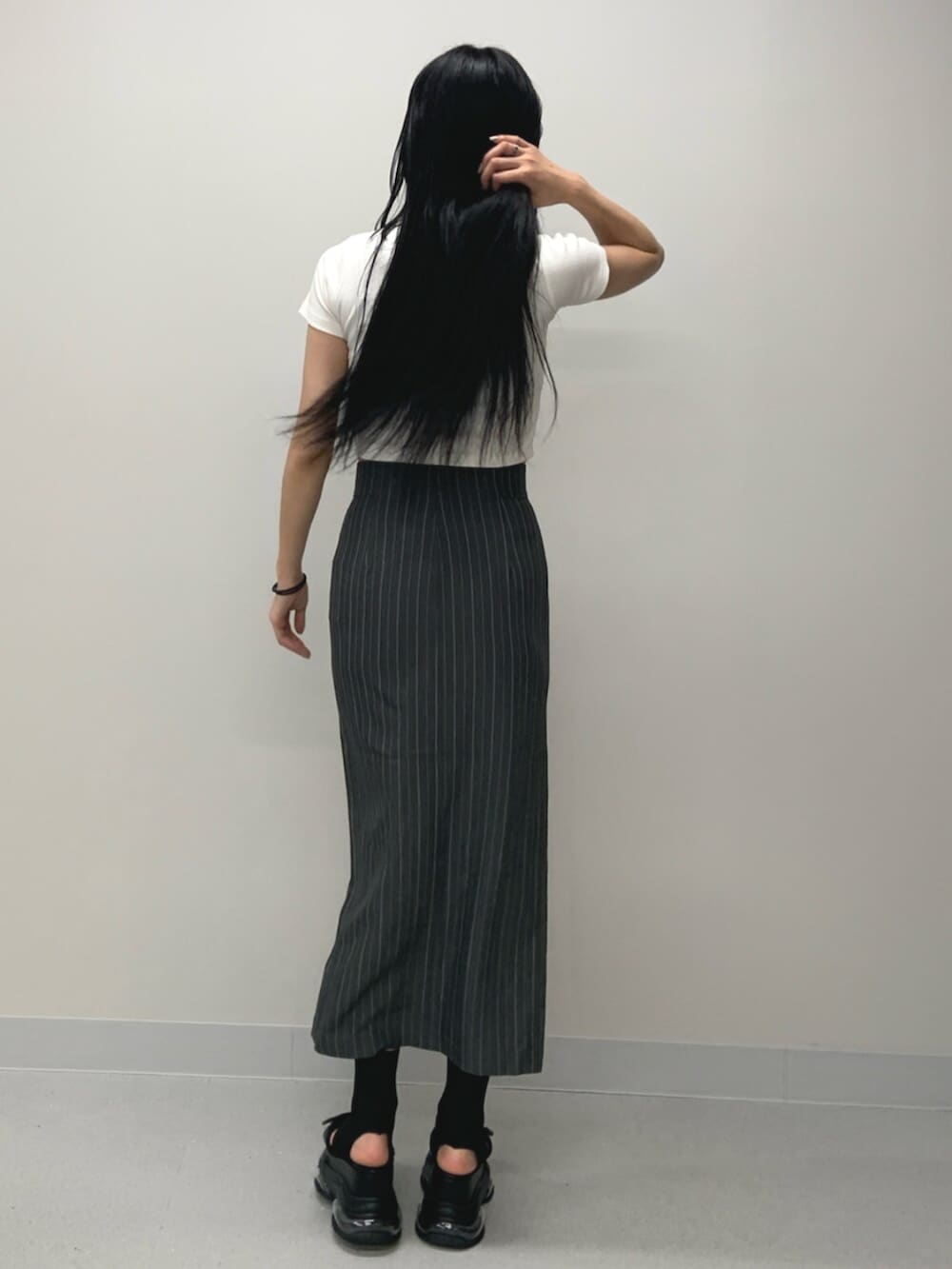 ブラック系のサンダル、ホワイト系のTシャツ/カットソー、グレー系のスカートを着用したレディースの春コーディネートの4枚目の写真