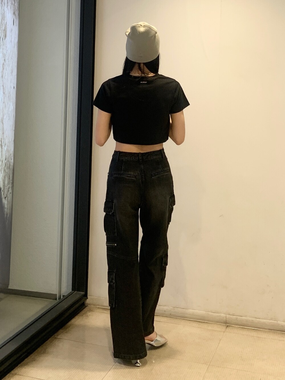 ブラック系のTシャツ/カットソー、ブラック系のデニムパンツ、シルバー系のサンダルを着用したレディースの春コーディネートの4枚目の写真