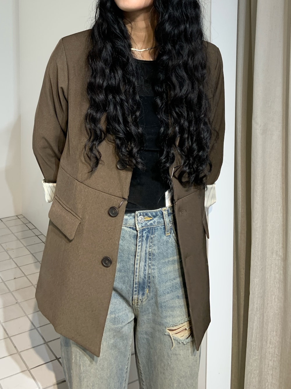 ブラウン系のブーツ、ブルー系のデニムパンツ、ブラウン系のテーラードジャケットを着用したレディースの秋コーディネートの4枚目の写真