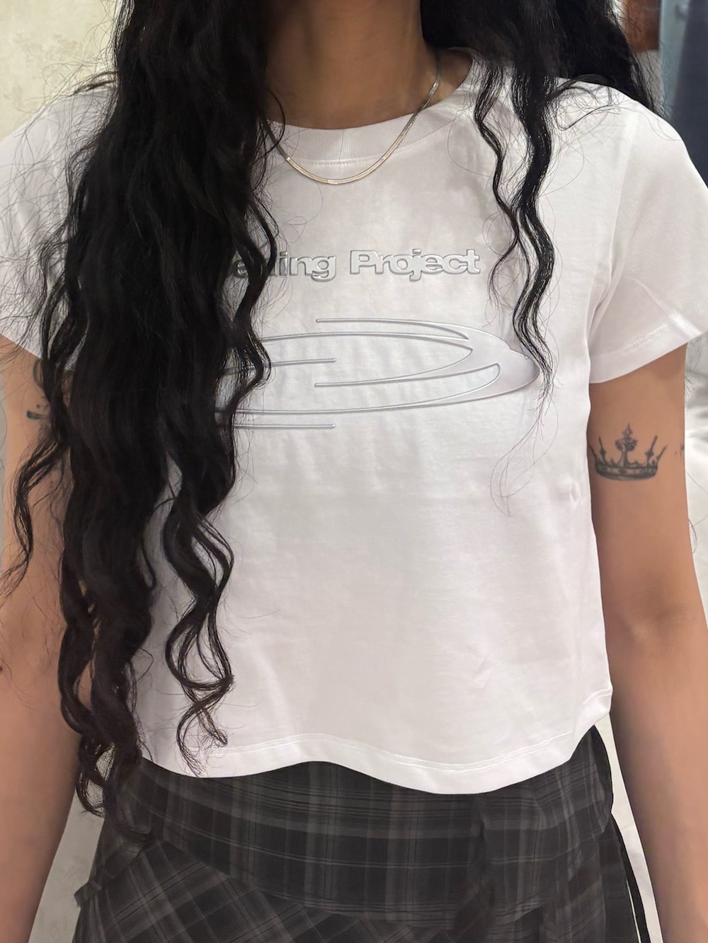 ホワイト系のTシャツ/カットソー、ブラック系のワンピース、ブラック系のブーツを着用したレディースの春コーディネートの4枚目の写真