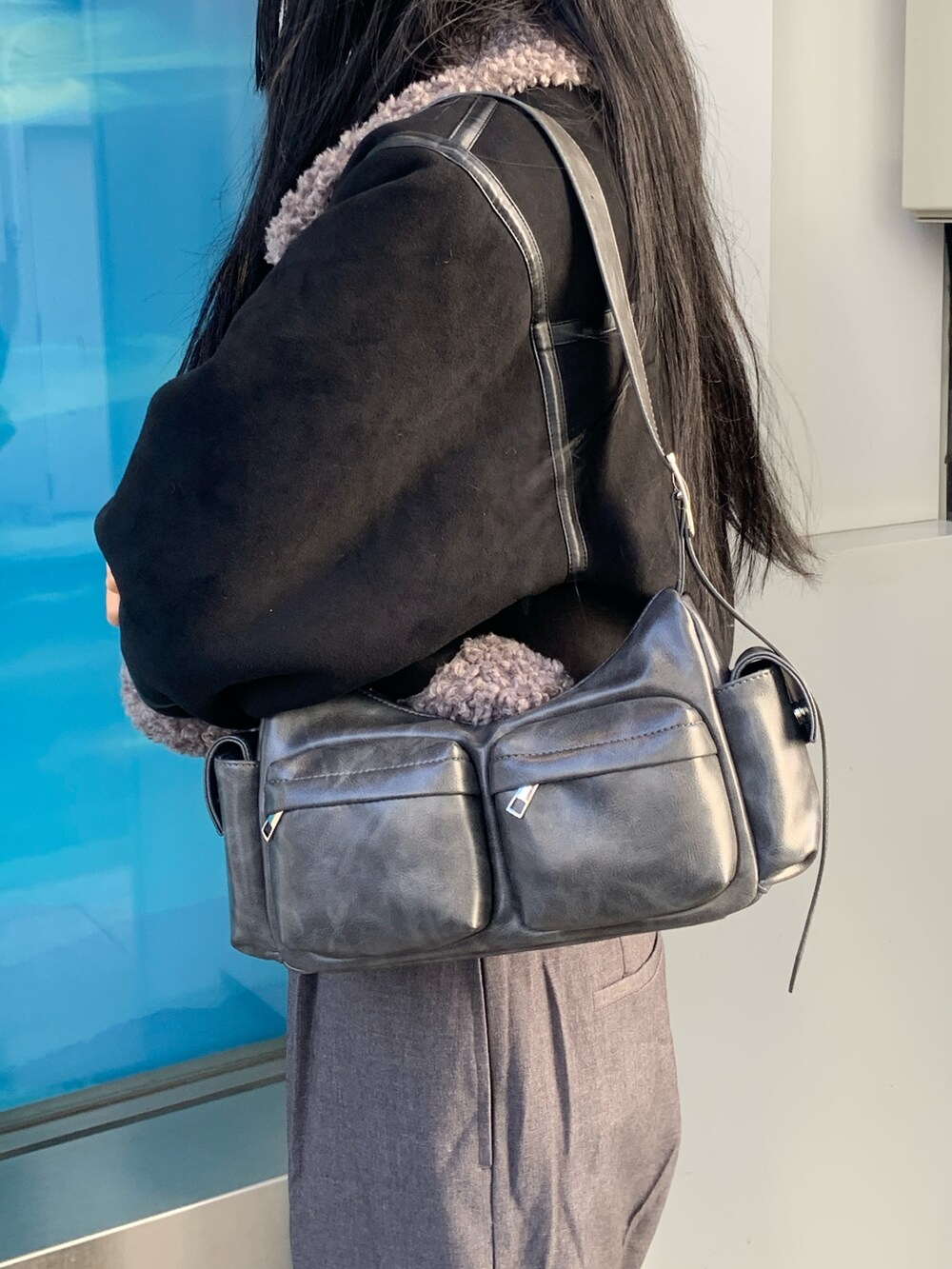 ブラック系のニット/セーター、グレー系のその他パンツ、ブラック系のムートンコートを着用したレディースの冬コーディネートの6枚目の写真