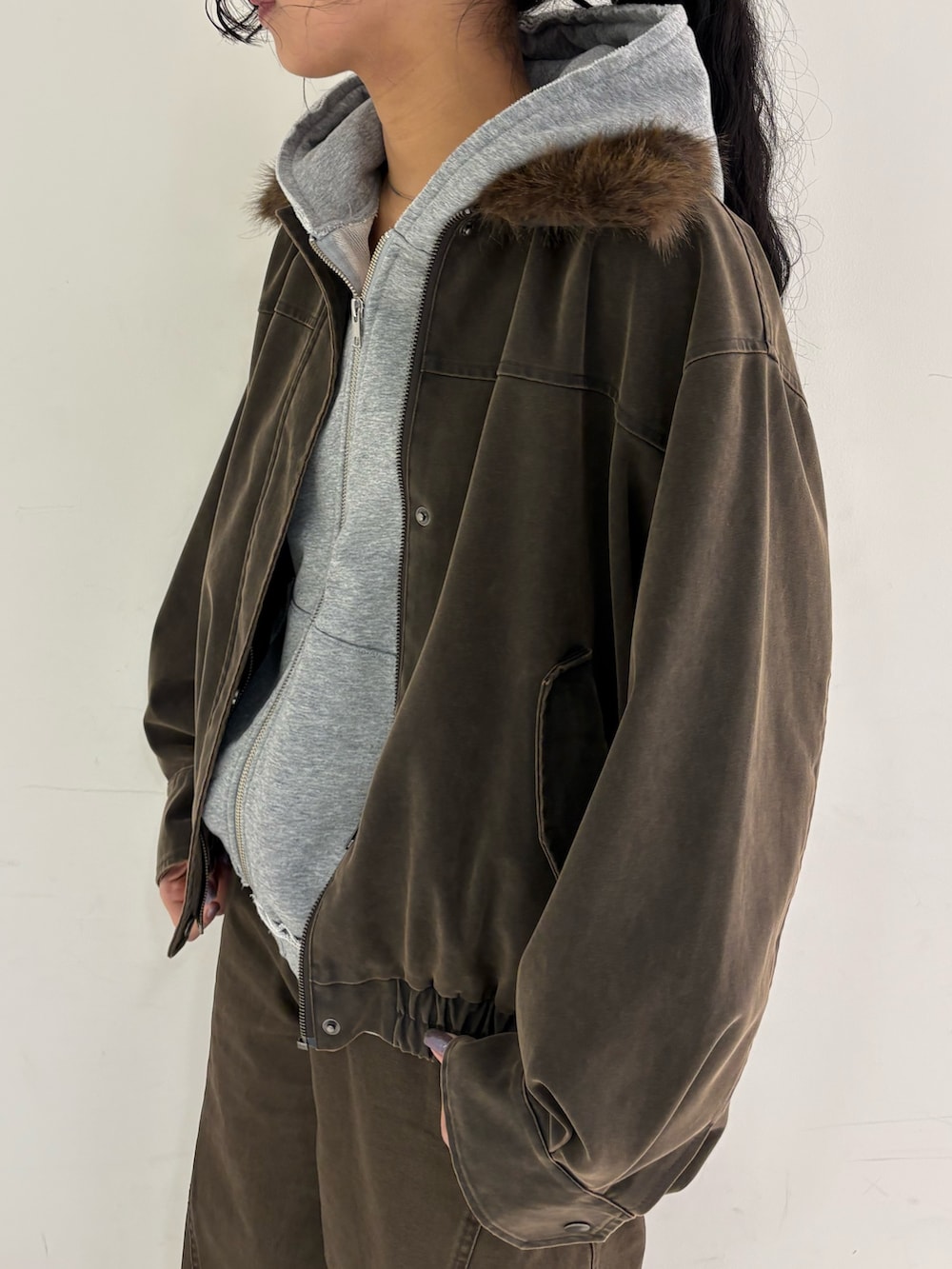 ブラウン系のブルゾン、グレー系のパーカー、ブラウン系のその他パンツを着用したレディースの冬コーディネートの4枚目の写真