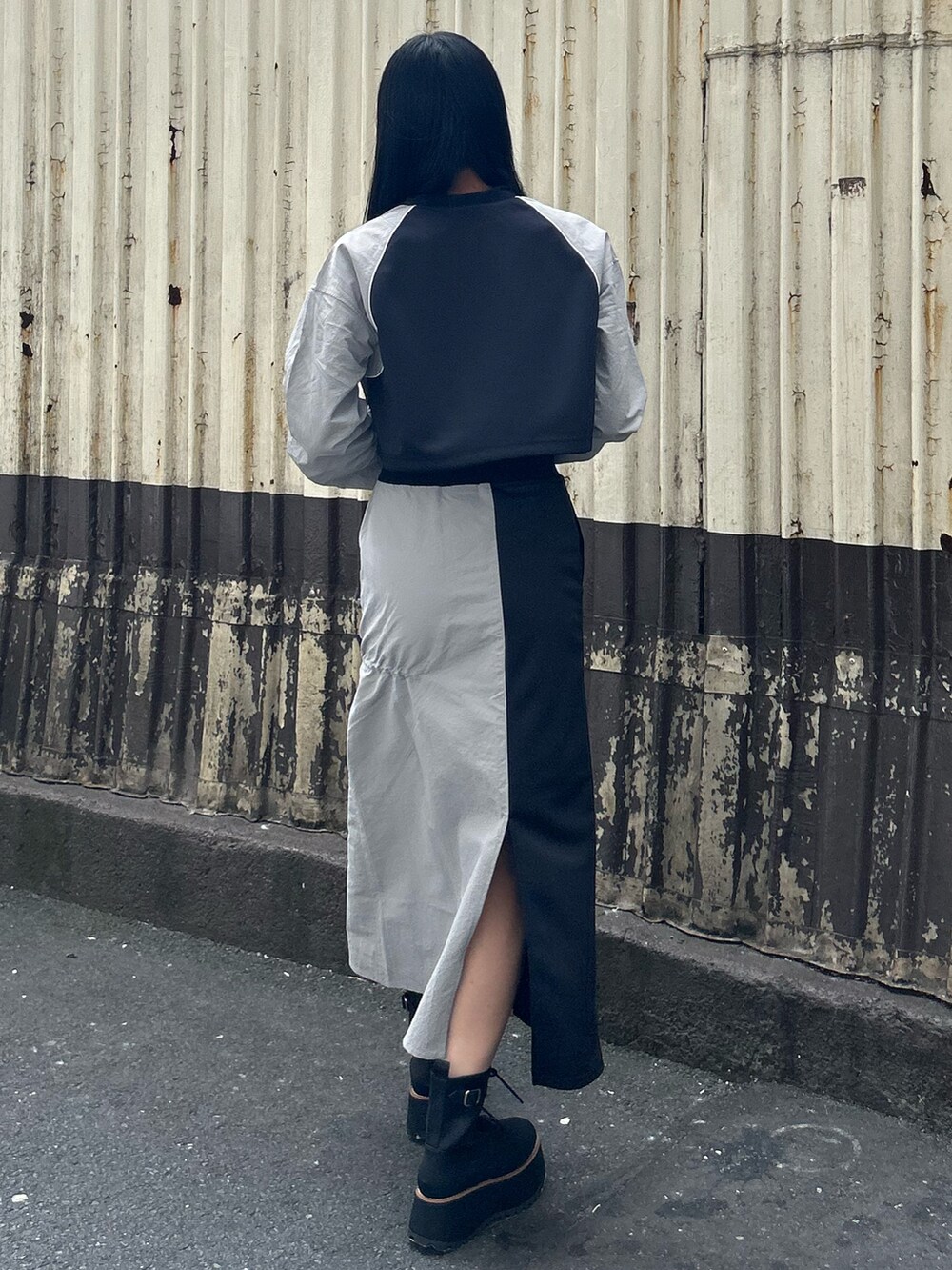 グレー系のTシャツ/カットソー、グレー系のスカート、ブラック系のブーツを着用したレディースの秋コーディネートの3枚目の写真