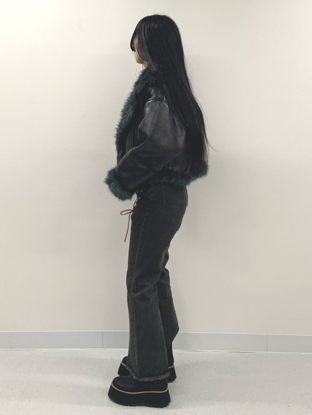 ブラック系のデニムパンツ、ブラック系のブーツ、ブラウン系のニット/セーターを着用したレディースの夏コーディネートの2枚目の写真