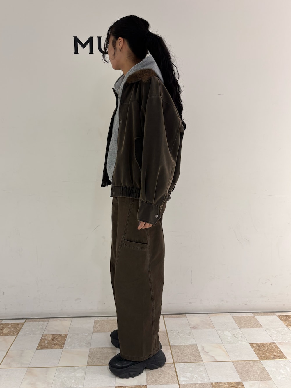 ブラウン系のブルゾン、グレー系のパーカー、ブラウン系のその他パンツを着用したレディースの冬コーディネートの2枚目の写真