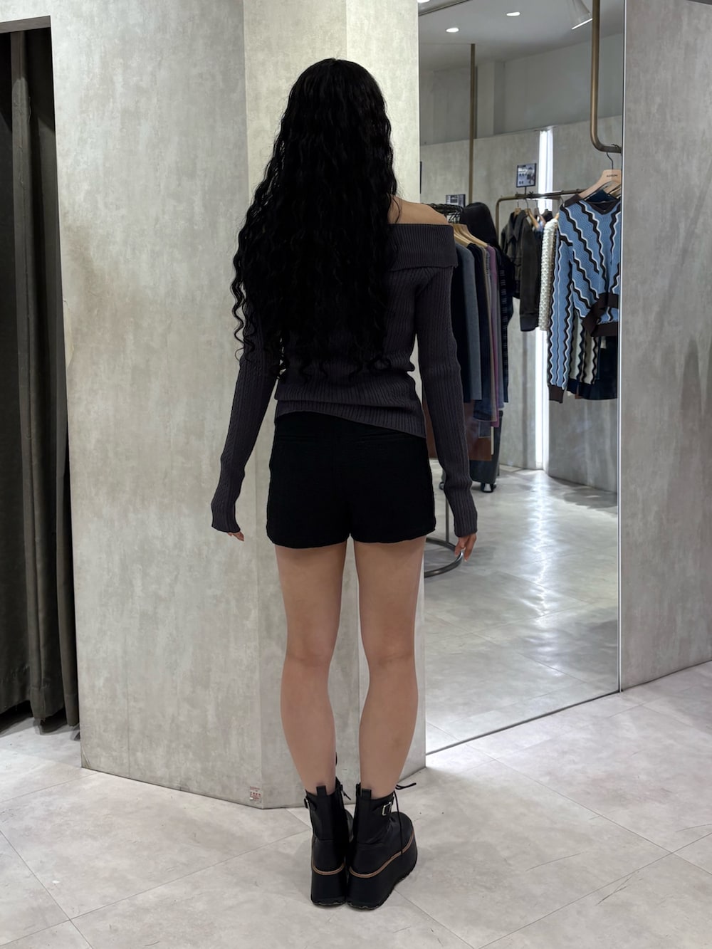 グレー系のニット/セーター、ブラック系のその他パンツ、ブラック系のブーツを着用したレディースの春コーディネートの3枚目の写真