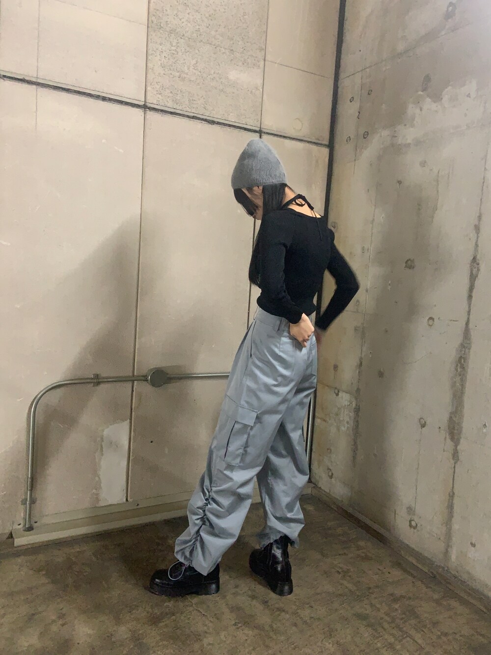 ブラック系のニット/セーター、ブルー系のカーゴパンツ、ブラック系のブーツを着用したレディースの冬コーディネートの2枚目の写真