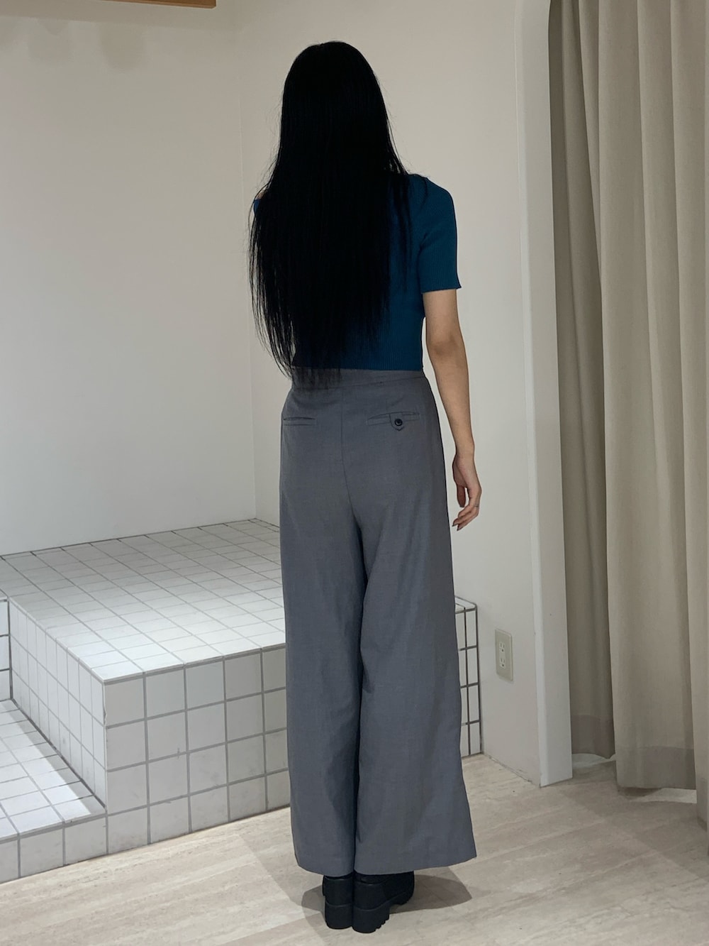 ブルー系のニット/セーター、グレー系のその他パンツ、ブラック系のサンダルを着用したレディースの夏コーディネートの4枚目の写真