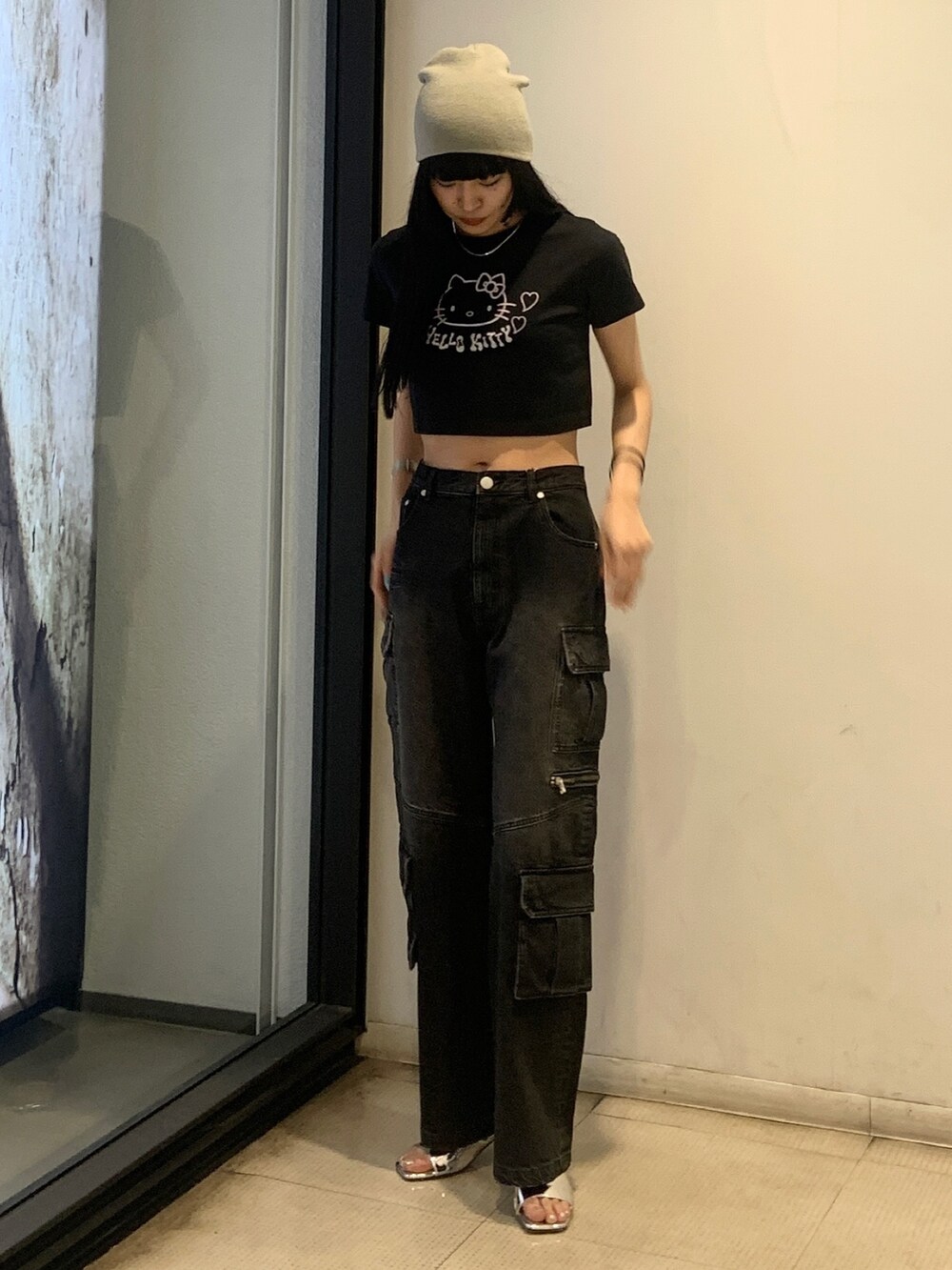 ブラック系のTシャツ/カットソー、ブラック系のデニムパンツ、シルバー系のサンダルを着用したレディースの春コーディネートの2枚目の写真