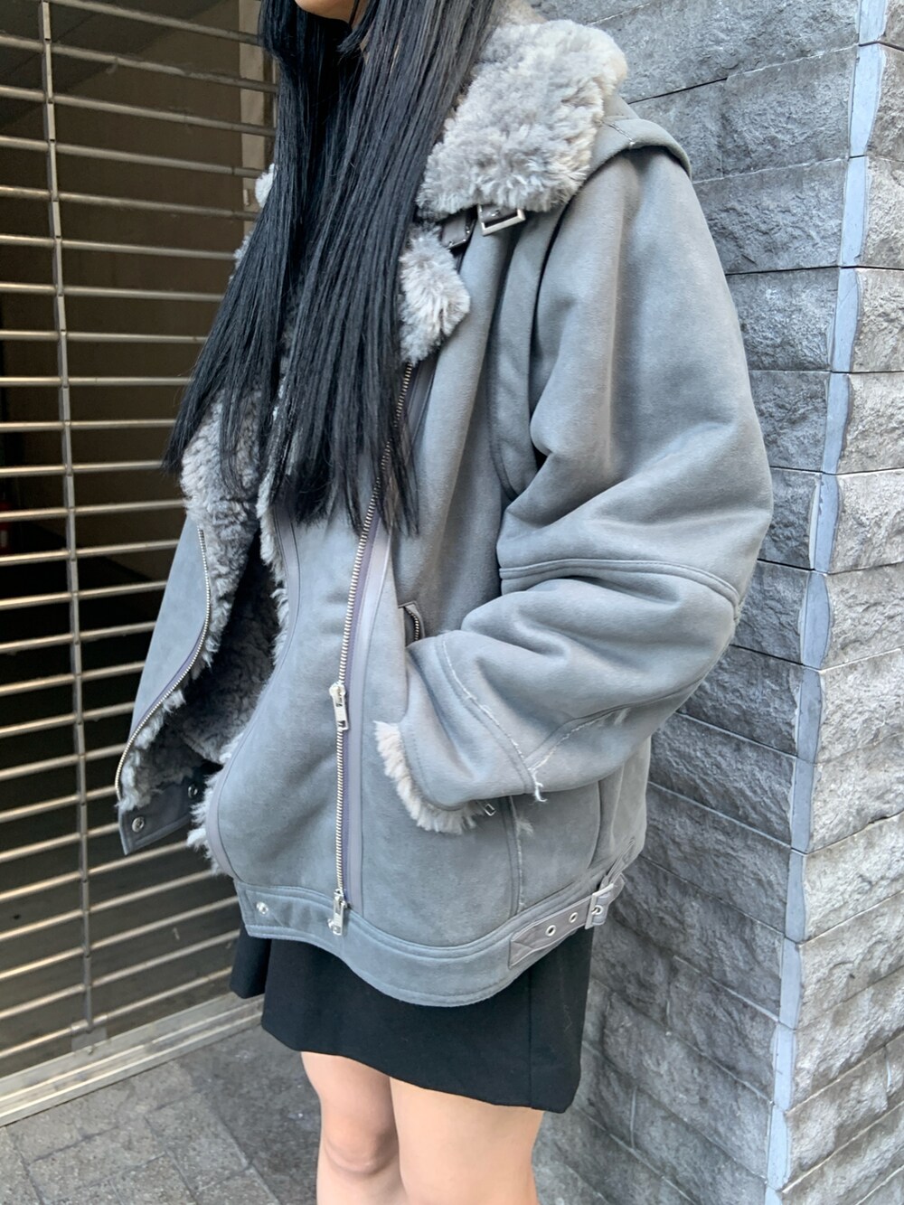 グレー系のムートンコート、ブルー系のニット/セーター、ブラック系のその他パンツを着用したレディースの冬コーディネートの6枚目の写真