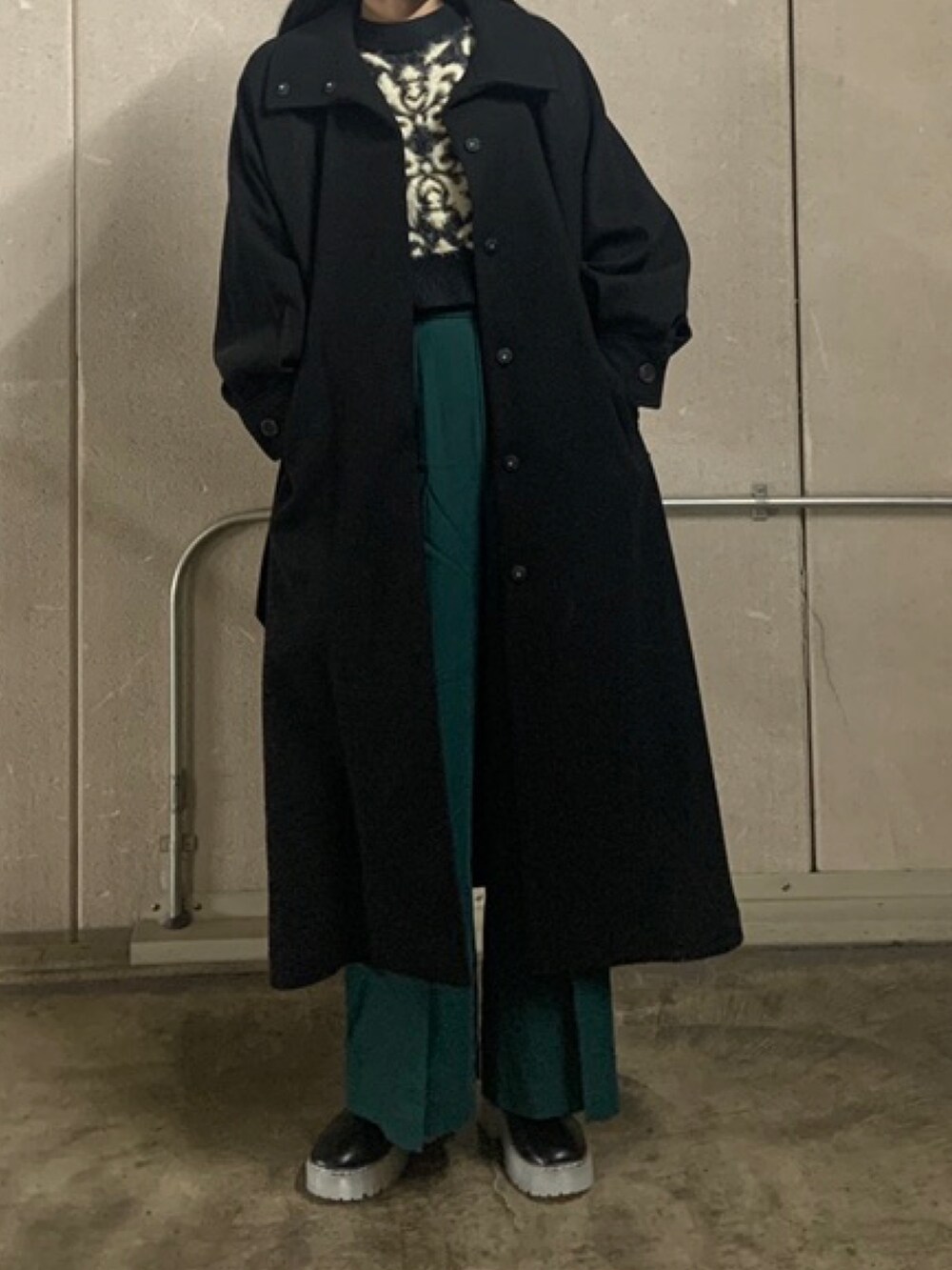 グリーン系のその他パンツ、ブラック系のニット/セーター、ブラック系のステンカラーコートを着用したレディースの秋コーディネートの3枚目の写真