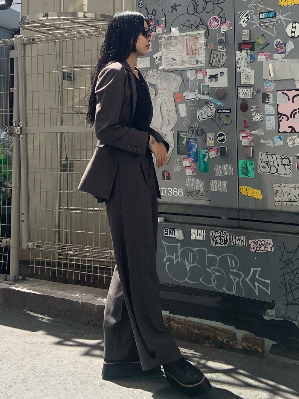 グレー系のテーラードジャケット、グレー系のその他パンツ、ブラック系のブーツを着用したレディースの秋コーディネートの3枚目の写真