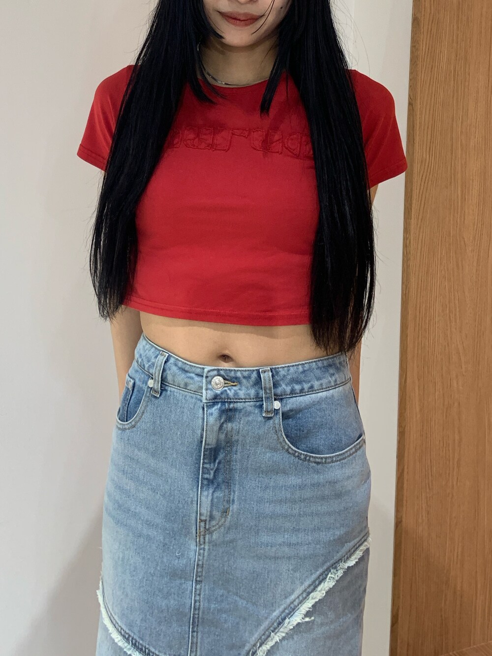 レッド系のTシャツ/カットソー、ブルー系のデニムスカート、ブラック系のブーツを着用したレディースの春コーディネートの5枚目の写真