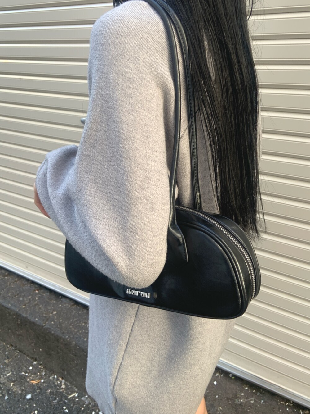 ブラック系のボストンバッグ、グレー系のワンピース、ブラック系のブーツを着用したレディースの冬コーディネートの6枚目の写真