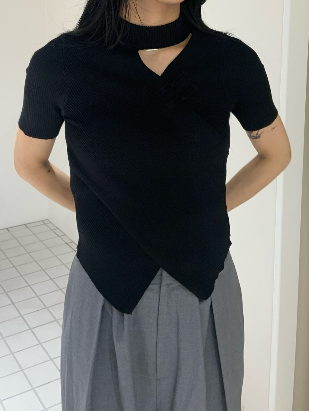 ブラック系のニット/セーター、グレー系のその他パンツ、ブラック系のサンダルを着用したレディースの夏コーディネートの4枚目の写真