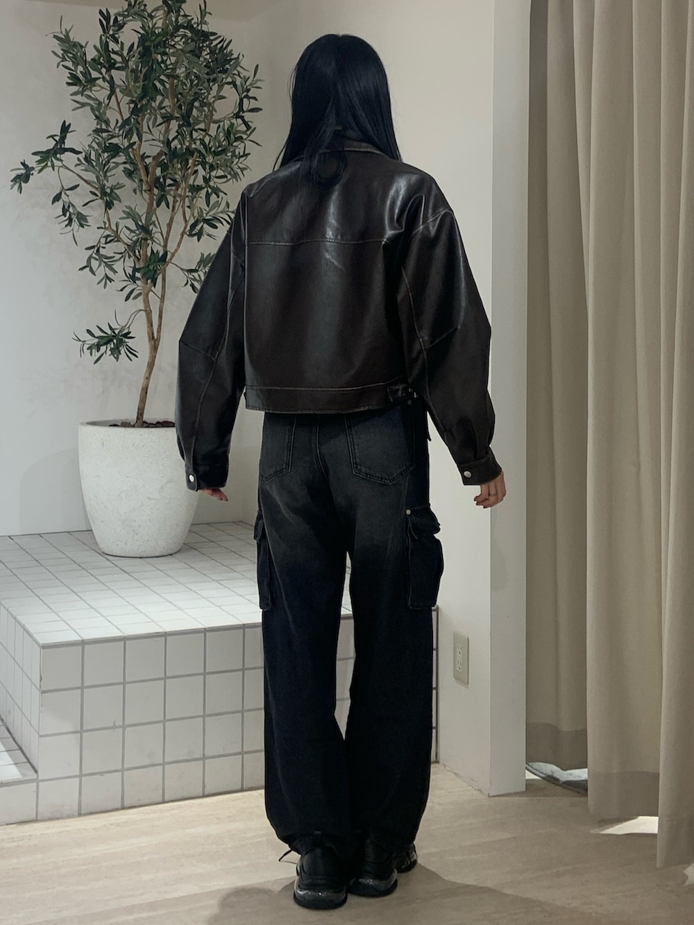 ブラウン系のブルゾン、ブルー系のタンクトップ、ブラック系のデニムパンツを着用したレディースの春コーディネートの4枚目の写真