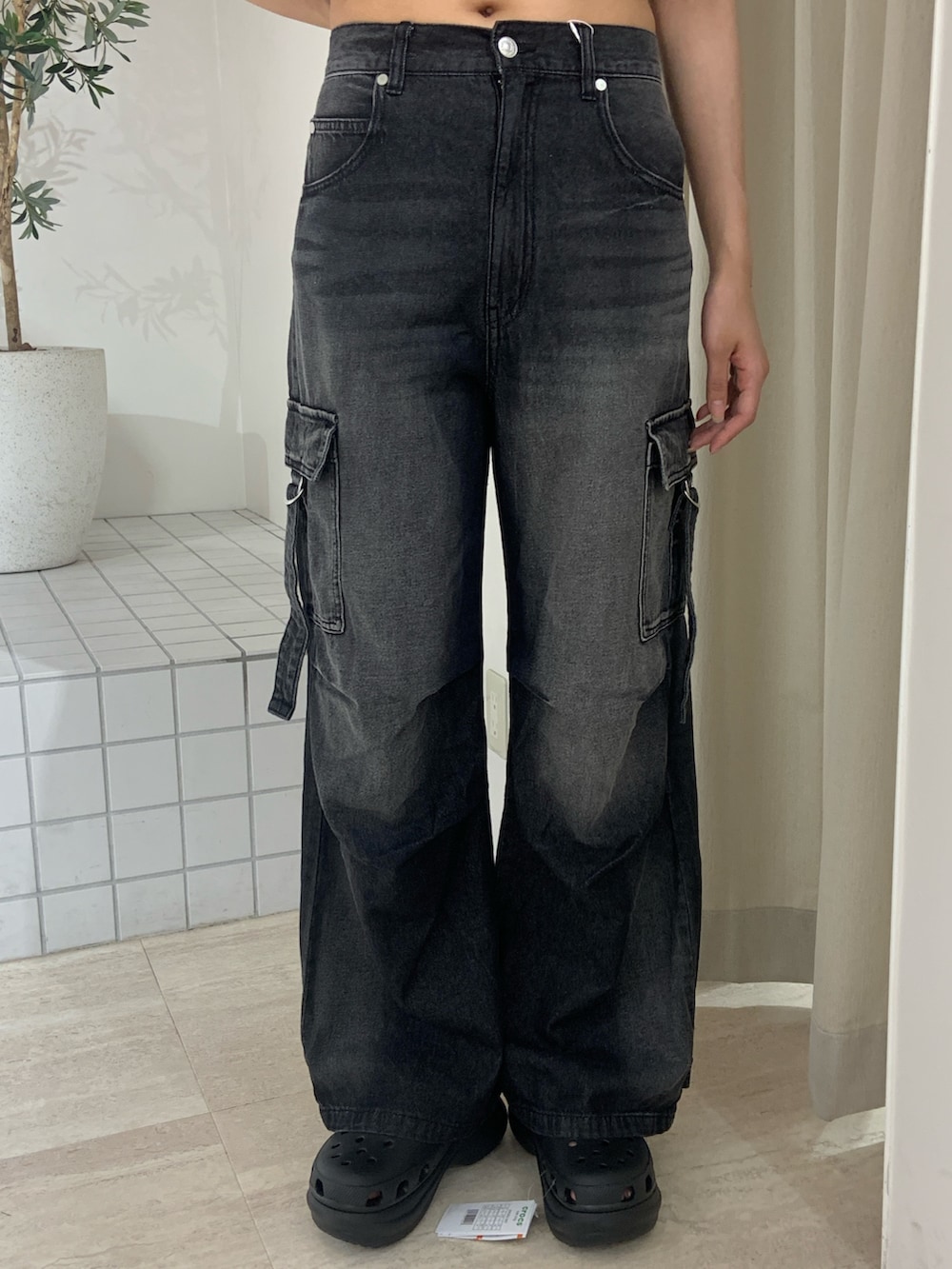 ブラック系のニット/セーター、ブラック系のデニムパンツ、ブラック系のサンダルを着用したレディースの夏コーディネートの6枚目の写真