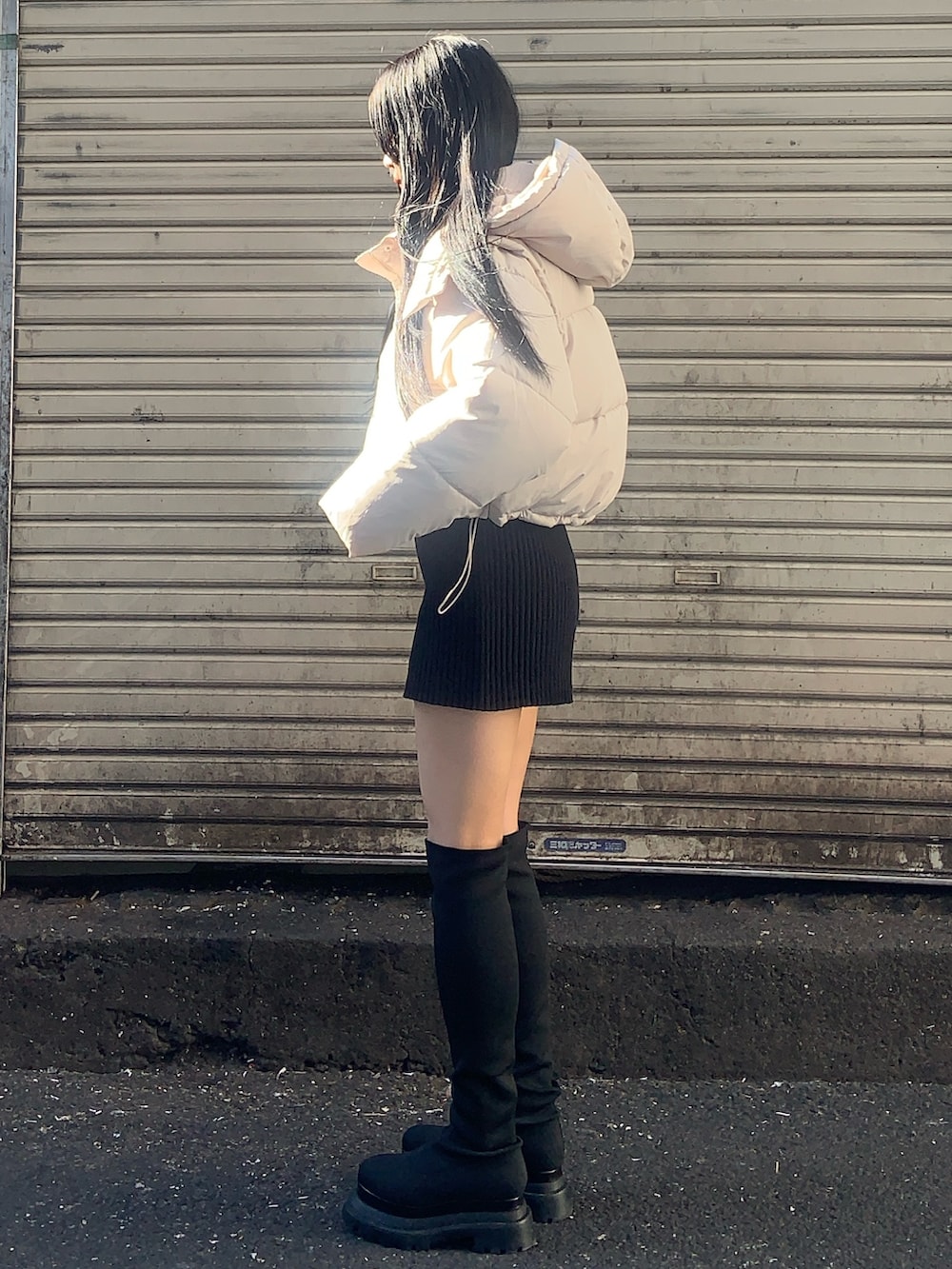 ホワイト系のブルゾン、ブラック系のニット/セーター、ブラック系のその他パンツを着用したレディースの冬コーディネートの2枚目の写真