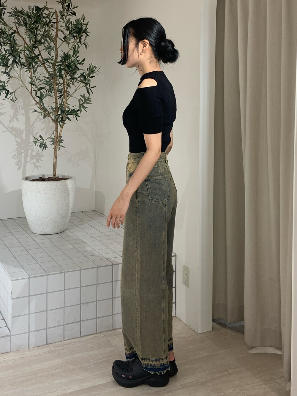 ブラック系のニット/セーター、その他のデニムパンツ、ブラック系のサンダルを着用したレディースの夏コーディネートの3枚目の写真