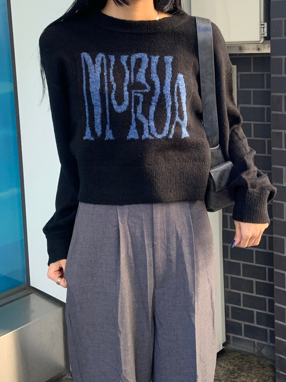 ブラック系のニット/セーター、グレー系のその他パンツ、ブラック系のムートンコートを着用したレディースの冬コーディネートの7枚目の写真