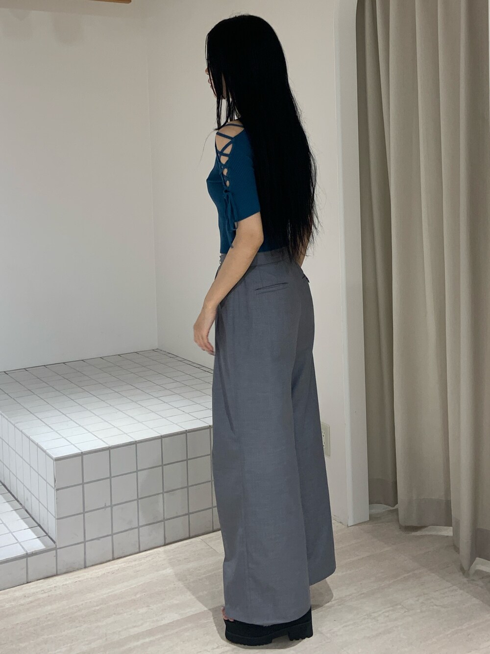 ブルー系のニット/セーター、グレー系のその他パンツ、ブラック系のサンダルを着用したレディースの夏コーディネートの3枚目の写真