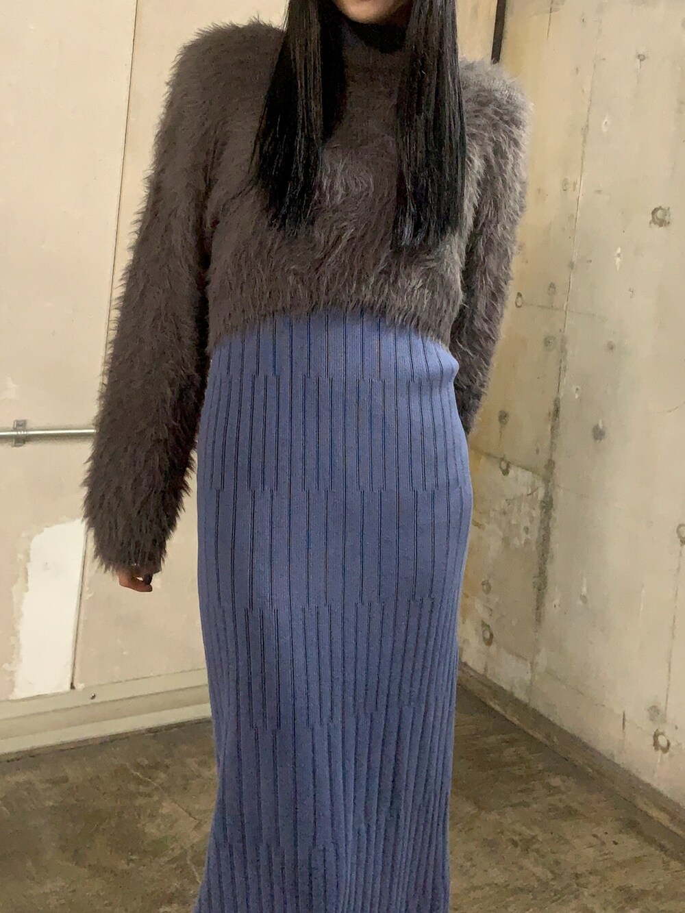 グレー系のニット/セーター、ブルー系のワンピース、ブラック系のブーツを着用したレディースの秋コーディネートの2枚目の写真