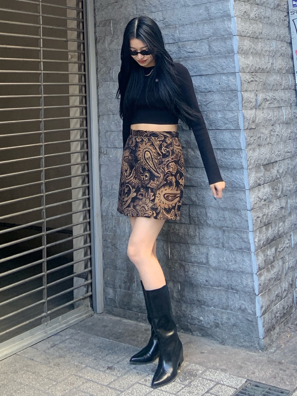 ブラック系のニット/セーター、ブラック系のスカート、ブラック系のブーツを着用したレディースの冬コーディネートの2枚目の写真