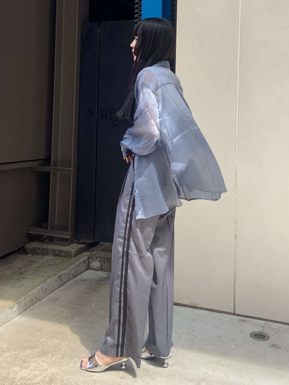 ブルー系のシャツ/ブラウス、ホワイト系のニット/セーター、グレー系のその他パンツを着用したレディースの春コーディネートの2枚目の写真