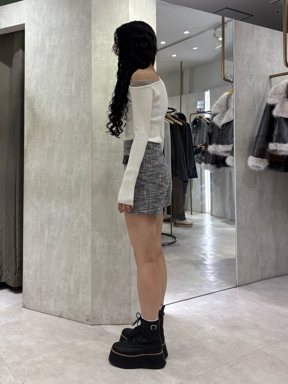 ホワイト系のニット/セーター、グレー系のその他パンツ、ブラック系のブーツを着用したレディースの冬コーディネートの2枚目の写真