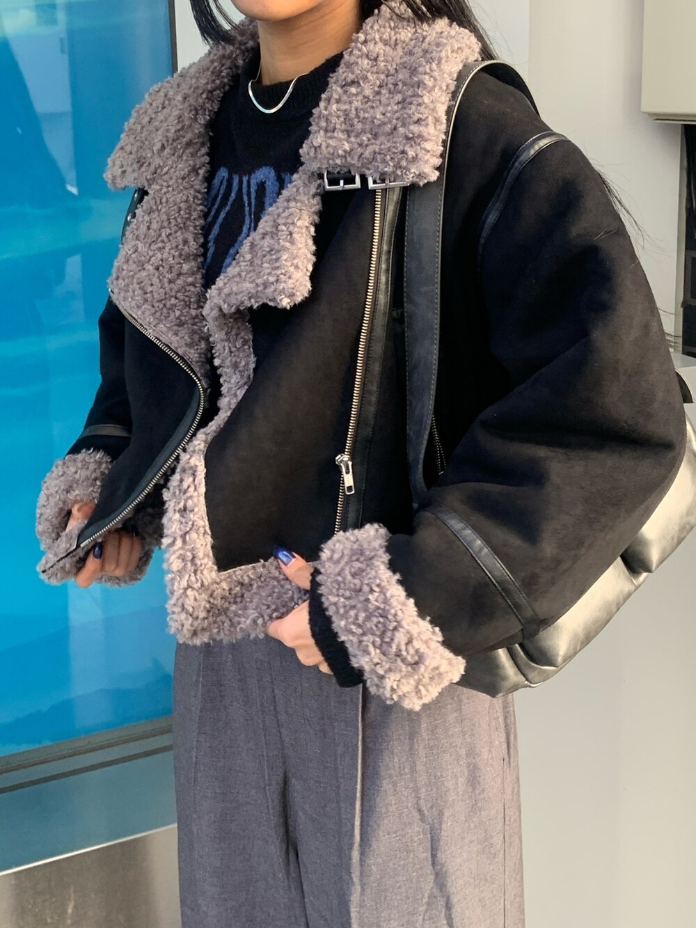 ブラック系のニット/セーター、グレー系のその他パンツ、ブラック系のムートンコートを着用したレディースの冬コーディネートの5枚目の写真