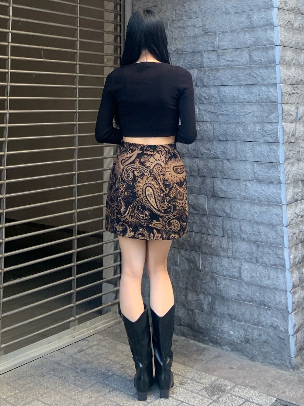 ブラック系のニット/セーター、ブラック系のスカート、ブラック系のブーツを着用したレディースの冬コーディネートの4枚目の写真