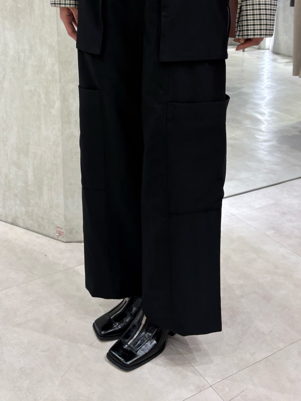 グレー系のニット/セーター、ブラック系のスラックス、ブラック系のパンプスを着用したレディースの春コーディネートの5枚目の写真