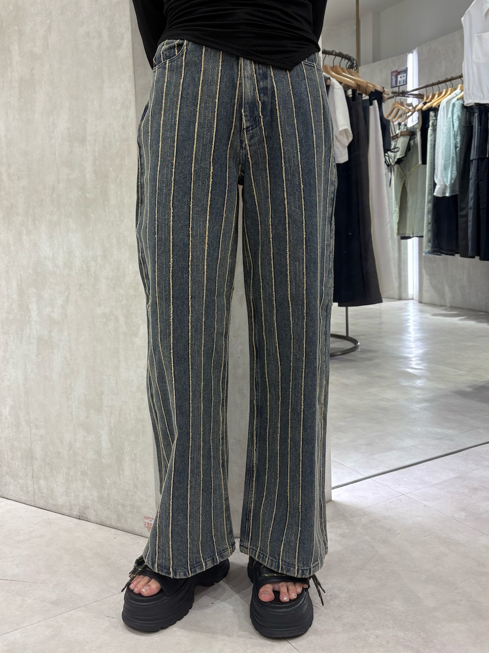 ベージュ系のニット/セーター、ブルー系のデニムパンツ、ブラック系のサンダルを着用したレディースの夏コーディネートの5枚目の写真