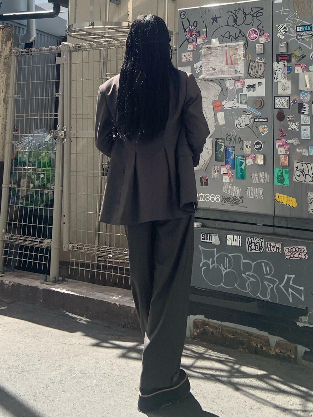 グレー系のテーラードジャケット、グレー系のその他パンツ、ブラック系のブーツを着用したレディースの秋コーディネートの4枚目の写真