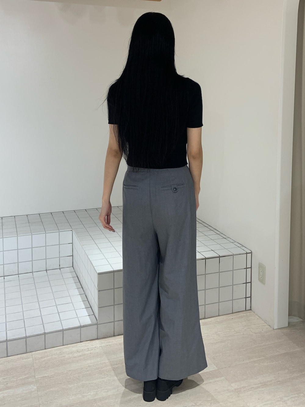 ブラック系のニット/セーター、グレー系のその他パンツ、ブラック系のサンダルを着用したレディースの夏コーディネートの3枚目の写真